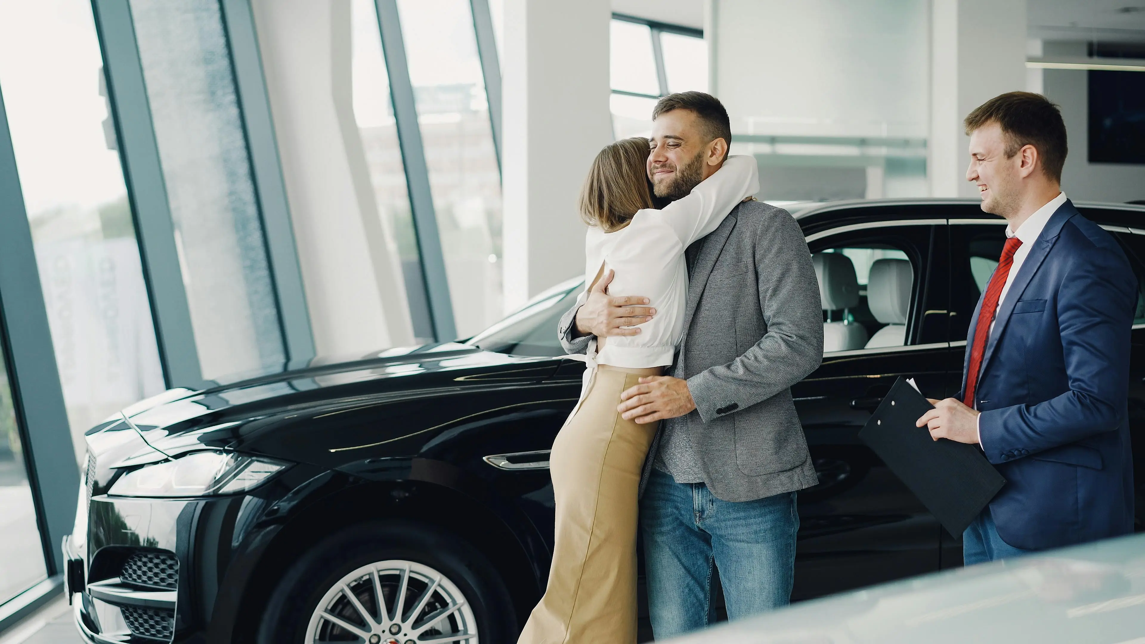 Customers celebrating a vehicle purchase at a dealership